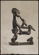 1 figurine blowing a pipe and holding a bird, standing in right profile