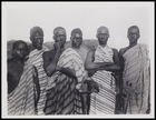 6 males standing and wearing striped bodycloths