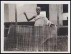 1 male in a body cloth holding a woven mat