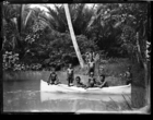 Man and group of children in a small (canvas ?) canoe on a river