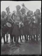boy carrying drum and crowd of men and young boys