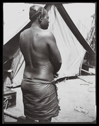 woman with semi-shaved head standing outside European tent