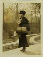 Photograph of a woman carrying food obtained from a London communal kitchen