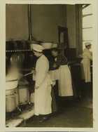 Photograph of an assistant preparing food in a communal kitchen