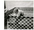 Black and white photograph of infant on checker board visual cliff
