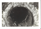 Black and White photograph of hole carved through center of log