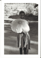 Black and White photograph of a young girl holding a large leaf