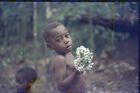 Close-up of Ngbanda, child holding a bunch of small white flowers.