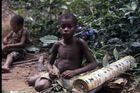 A youth, Pumbwa, sat on the forest floor looking at the camera.