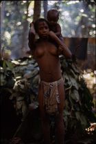 A young woman, Goma, carrying a child (her cousin, Etu) on her shoulders.