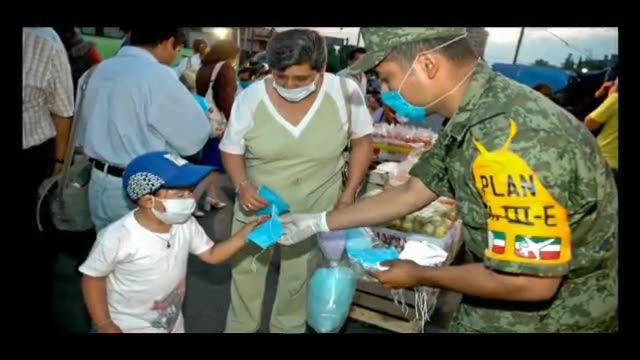 Soldier distributes protective gear to boy and woman